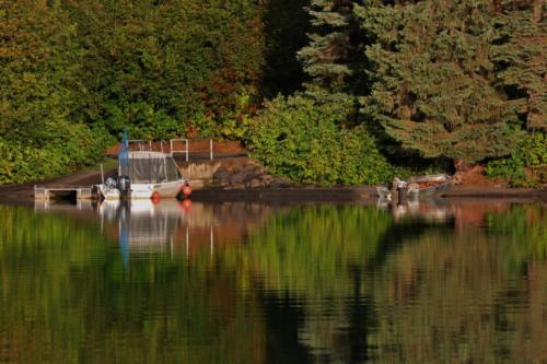 Dock and boat reflections, Meziadin Lake, BC